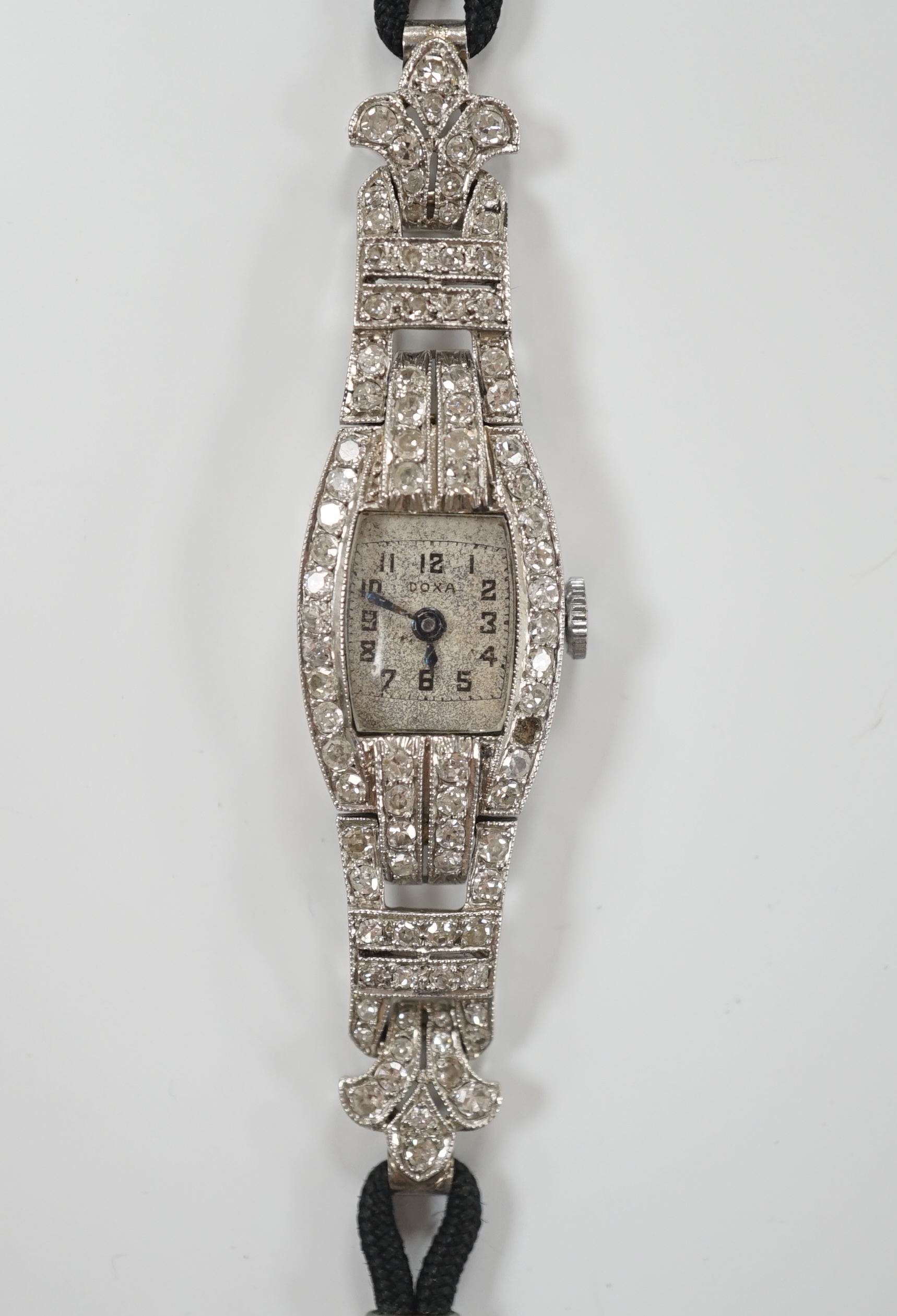 A lady's 1930's/1940's French white metal (platinum mark) and diamond cluster set manual wind cocktail watch, on a twin fabric strap, with metal clasp.